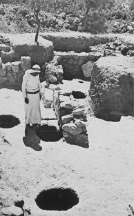 Photo of men standing by cellar holes.