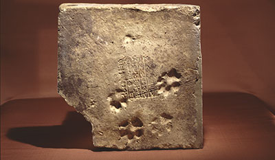 A brick with a cuneiform seal stamped into it.