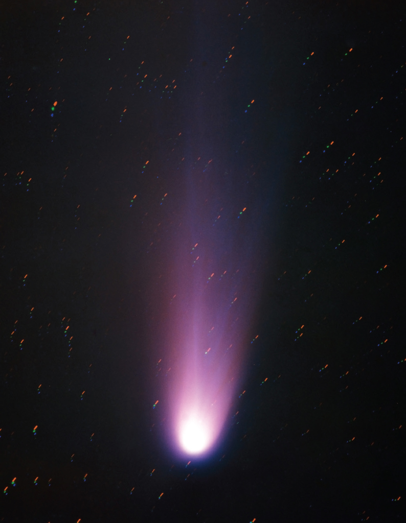 A photo of a bright white comet with purple tail in the night sky
