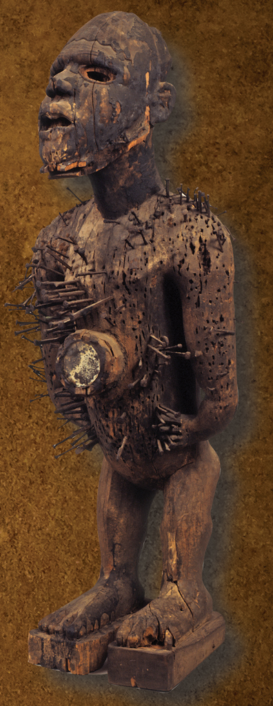 Weathered wooden figure of a human with nails sticking out all over