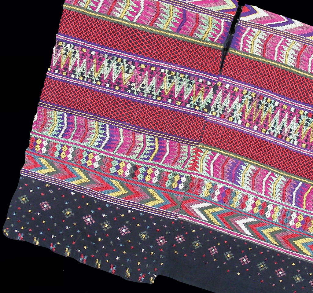 Two piece huipil made of black cotton almost completely covered by brocaded geometric designs in red, yellow, lavender, green, blue and white cotton and green, deep rose, and purple silk, multicolored dots along the lower border.