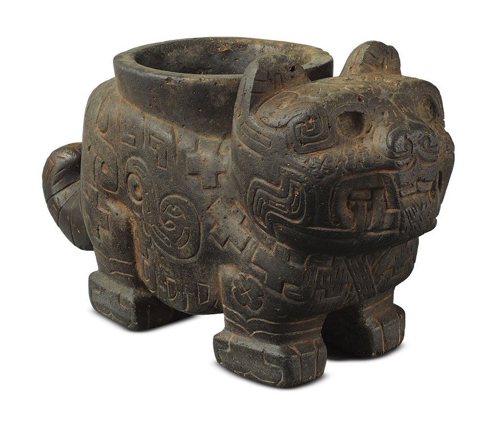 A stone jaguar vessel with geometric motifs carved on it.