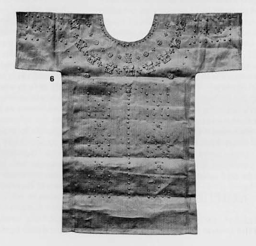 A tunic with small gold animal figures and studs sewn on to it.