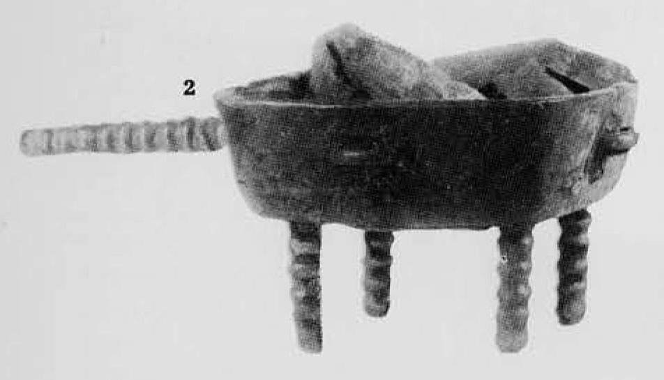 A censer with four legs and a handle.