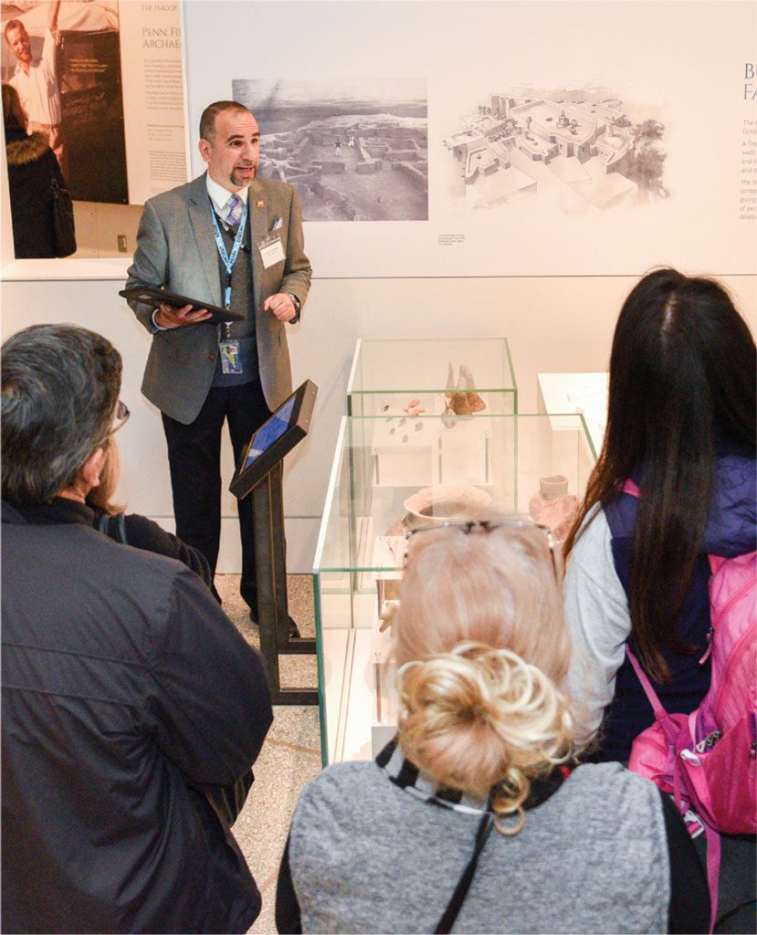 A Global uide in the Middle East Galleries giving a tour to guests.