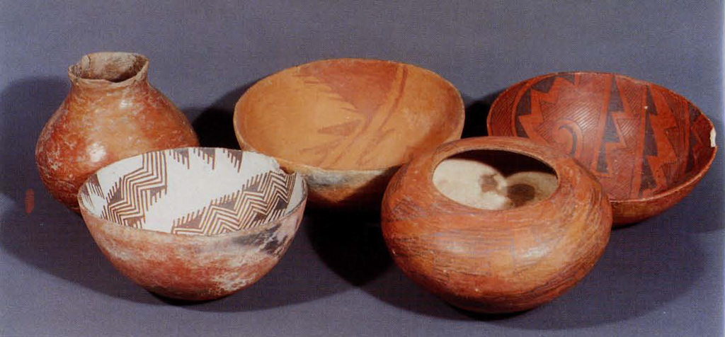Five red ware vessels featuring geometric patterns.