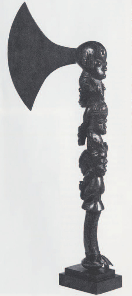 Ceremonial axe, handle carved into several heads one atop another, facing alternating directions.