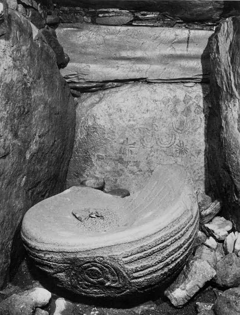 A stone basin and back stone with carved decor.