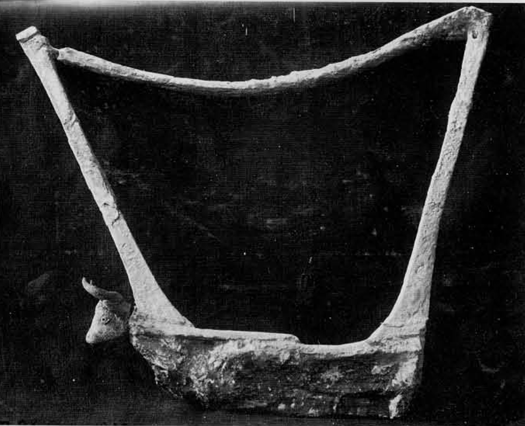 A cast of a lyre adorned with a horned bull head at the front.