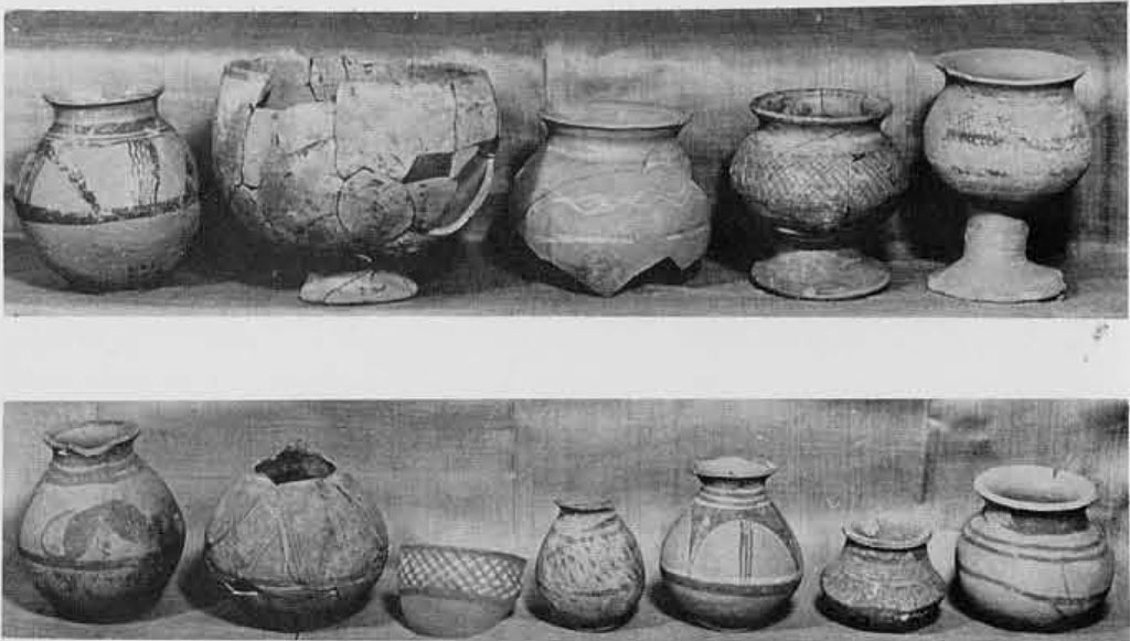 Several pttery vases and vessels with round bodies and flared necks, some pieced together from fragments.