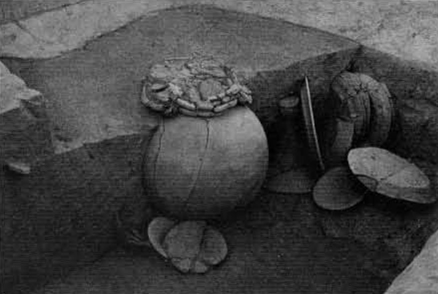 A burial with a large urn and assorted pottery.