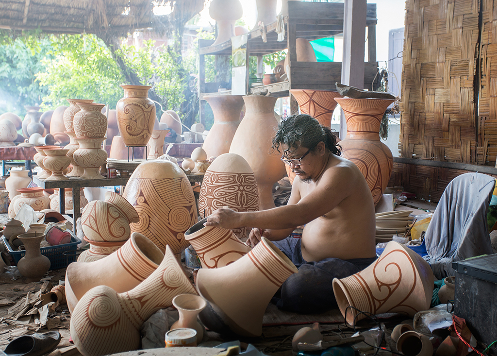 An artisan painting pottery.