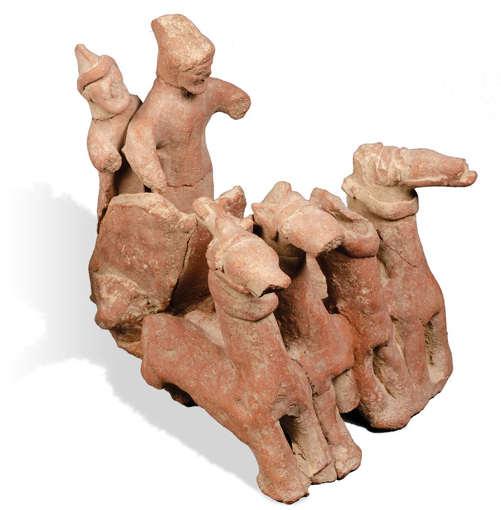 A clay figurine of two charioteers with a team of four horses.