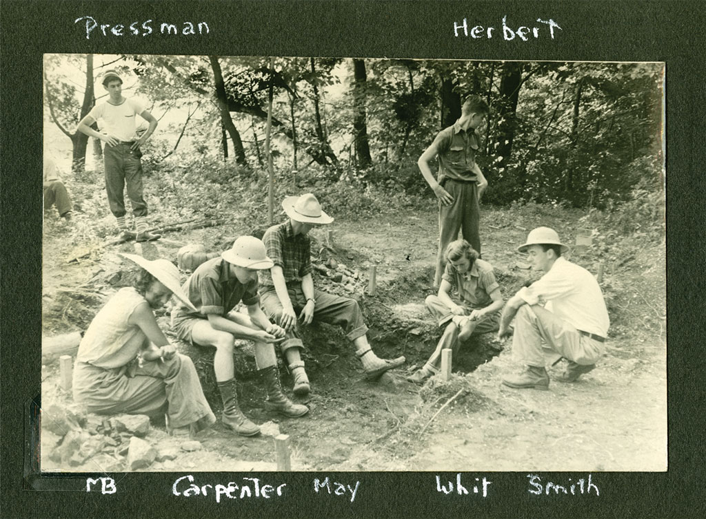 Photo of archaeologists around a dig site.