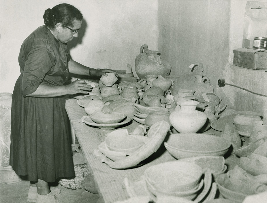A woman handling pottery.