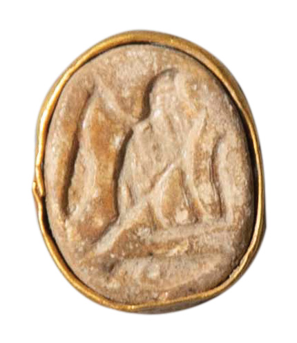 A round amulet with a falcon engraved on it.