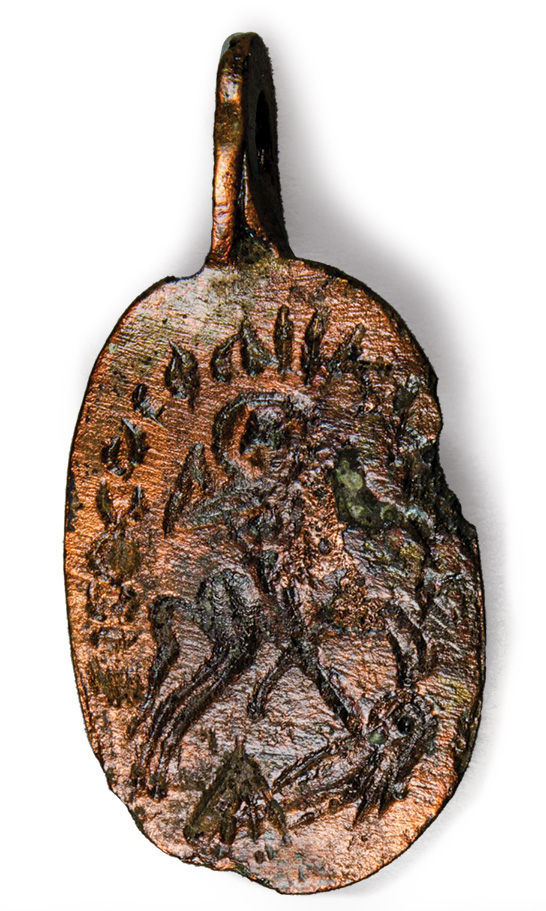 A bronze amulet with an engraving of a rider stabbing someone.