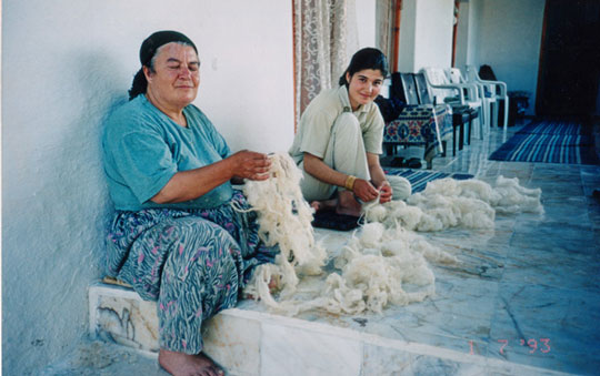 Two women working with white yarn.