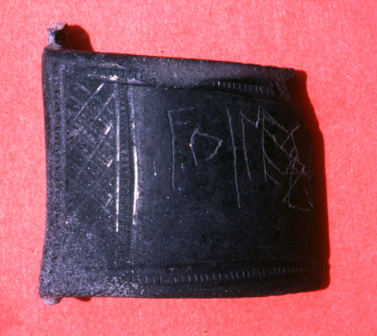 A pottery fragment with a partial inscription.