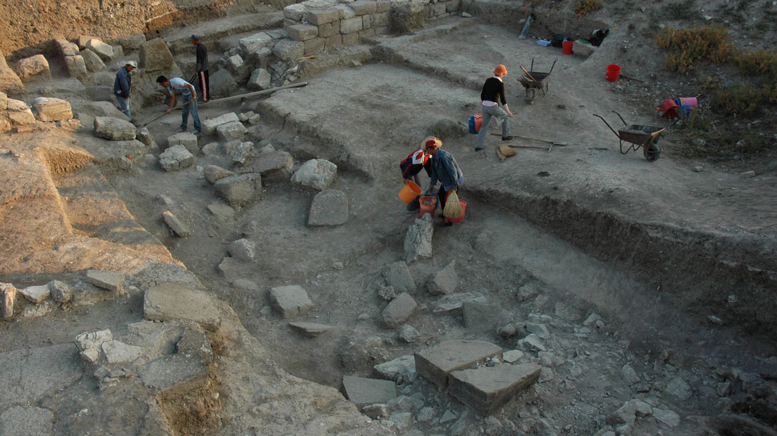 Workers at the Gordion excavations loading debris into wheelbarrows.