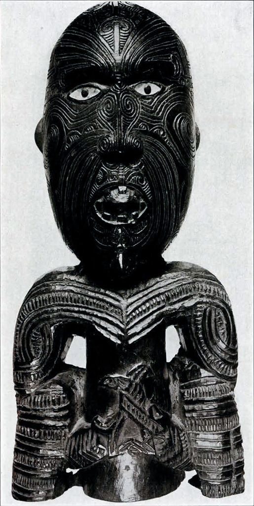 A wooden figure with an enlarged head showing moko markings