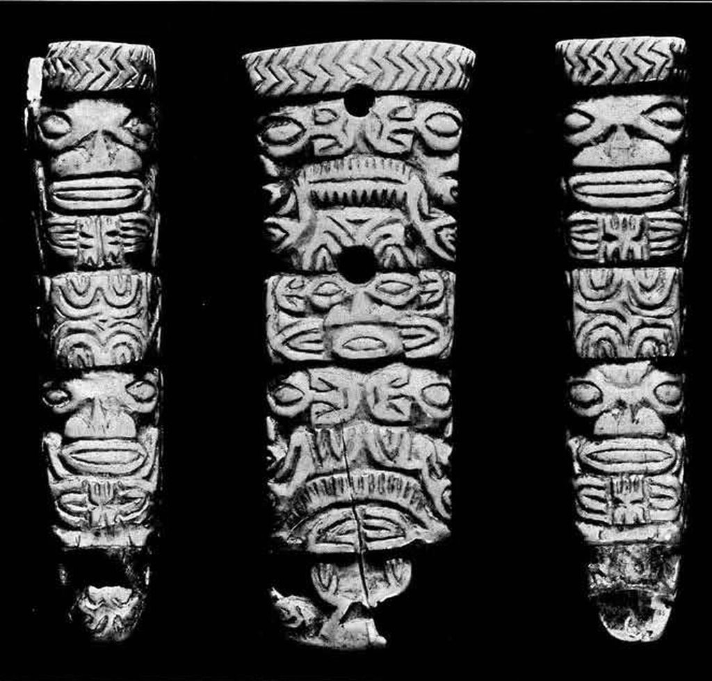close up of a fan handle carved into human and animal figures