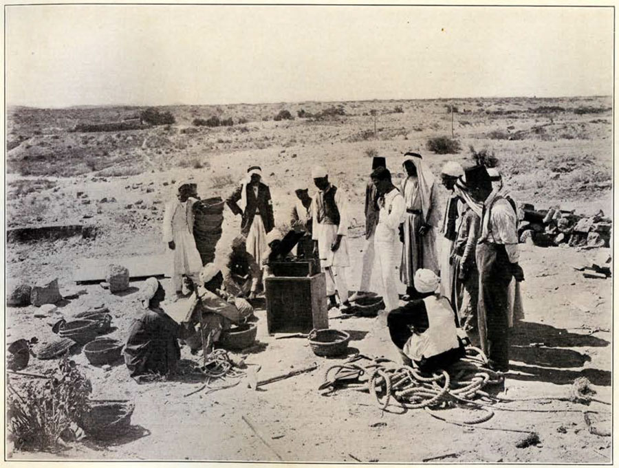 Workmen in the desert gathered around a phonograph