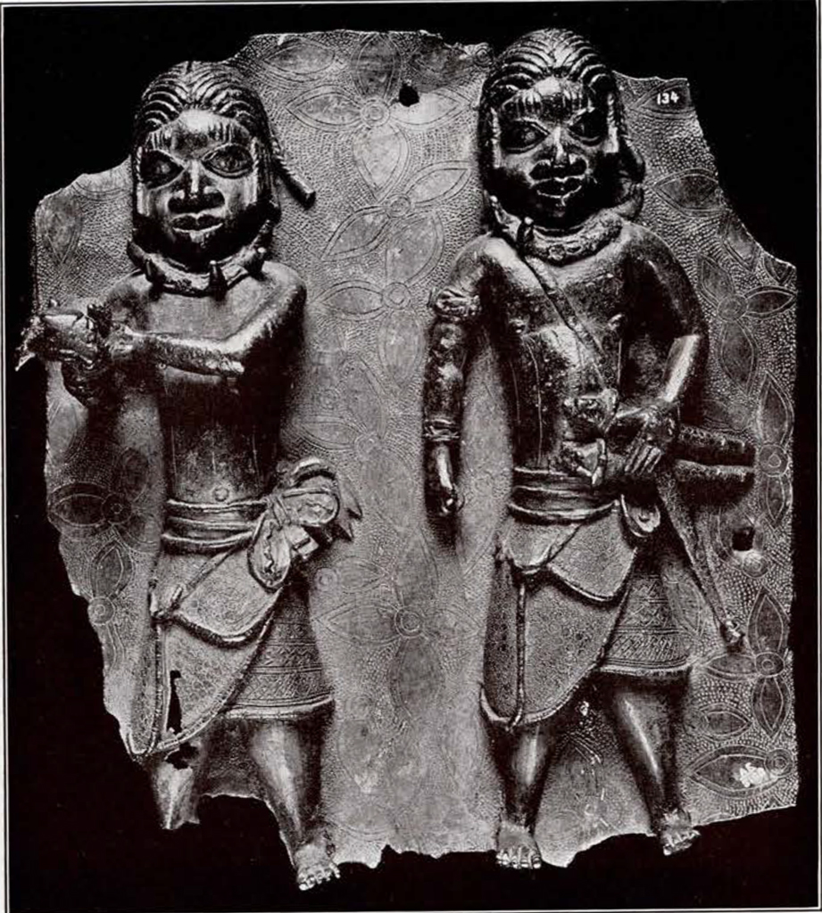 bronze plaque of two warriors in skirts presenting a sacrifice in relief