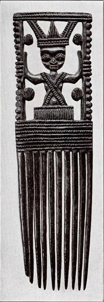 a hair comb with a figure carved into the handle