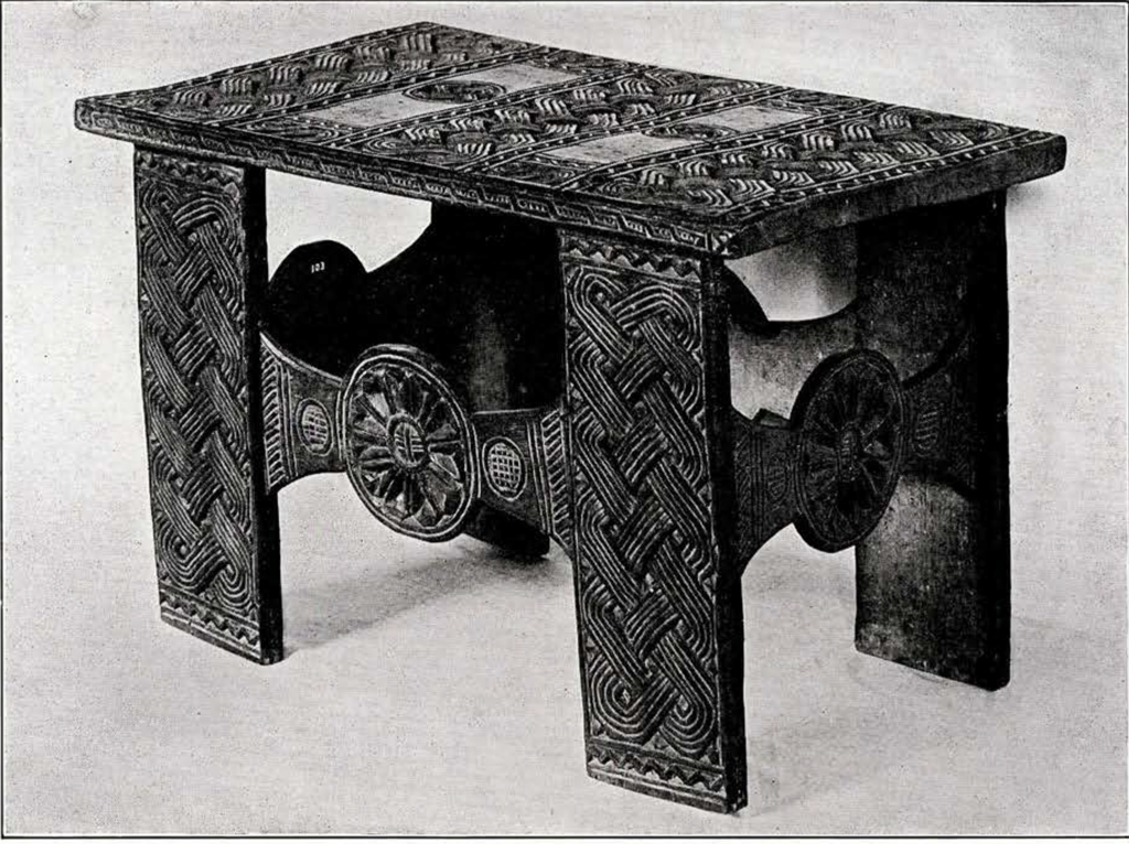 a carved wood table with a intricate pattern of interlocking lines