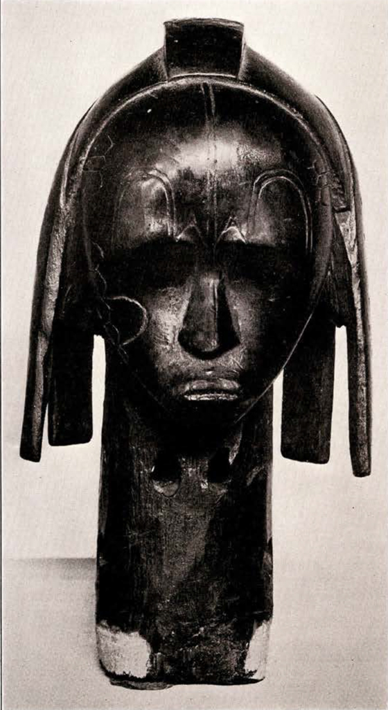 Wood head with long neck, four long wide hair pieces hanging down, and one short wide hair piece along the crest, from the front