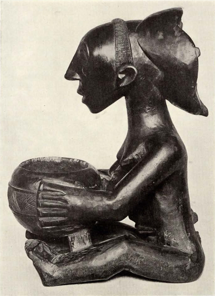 Wood carved seated woman holding a bowl, profile view