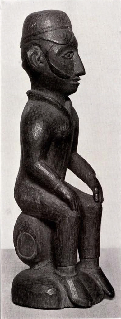 Wood carved figure seated on a barrel