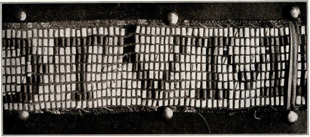 Close up of beading on a wampum belt, letter M