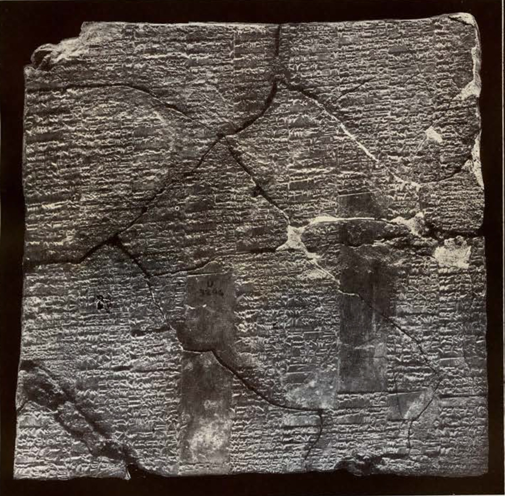 a large clay tablet with closely packed inscription,  cracked and broken, pieced together