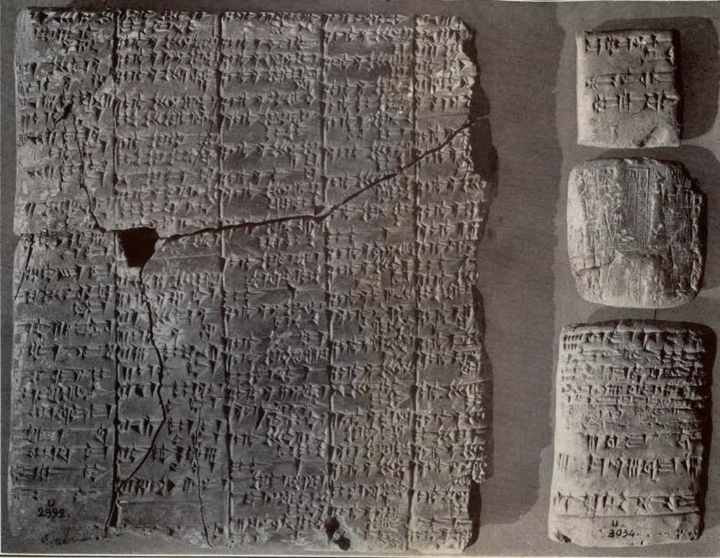 a large tablet with inscription, fragmented and pieced together, and three small tablets