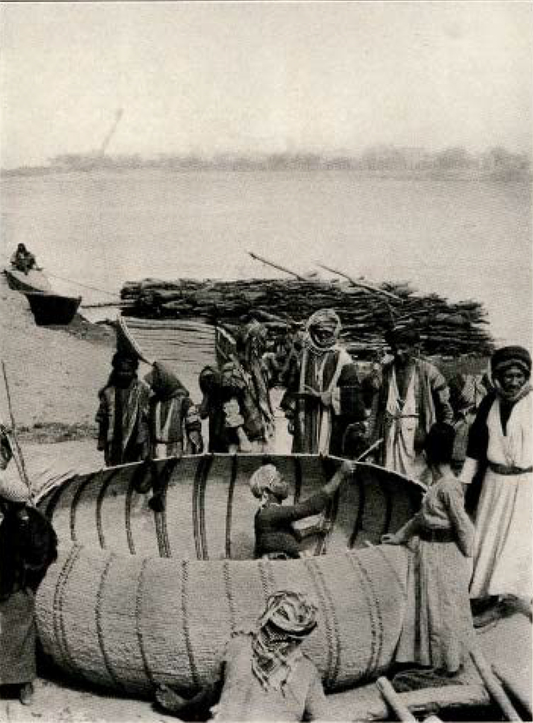 Group of men building a circular boat with rounded sides on a river bank, one man inside the boat