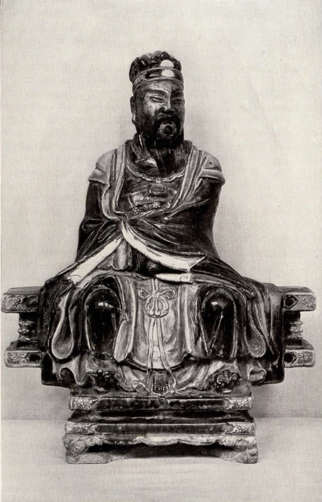 male figure seated on a blank wrapped in draping robes