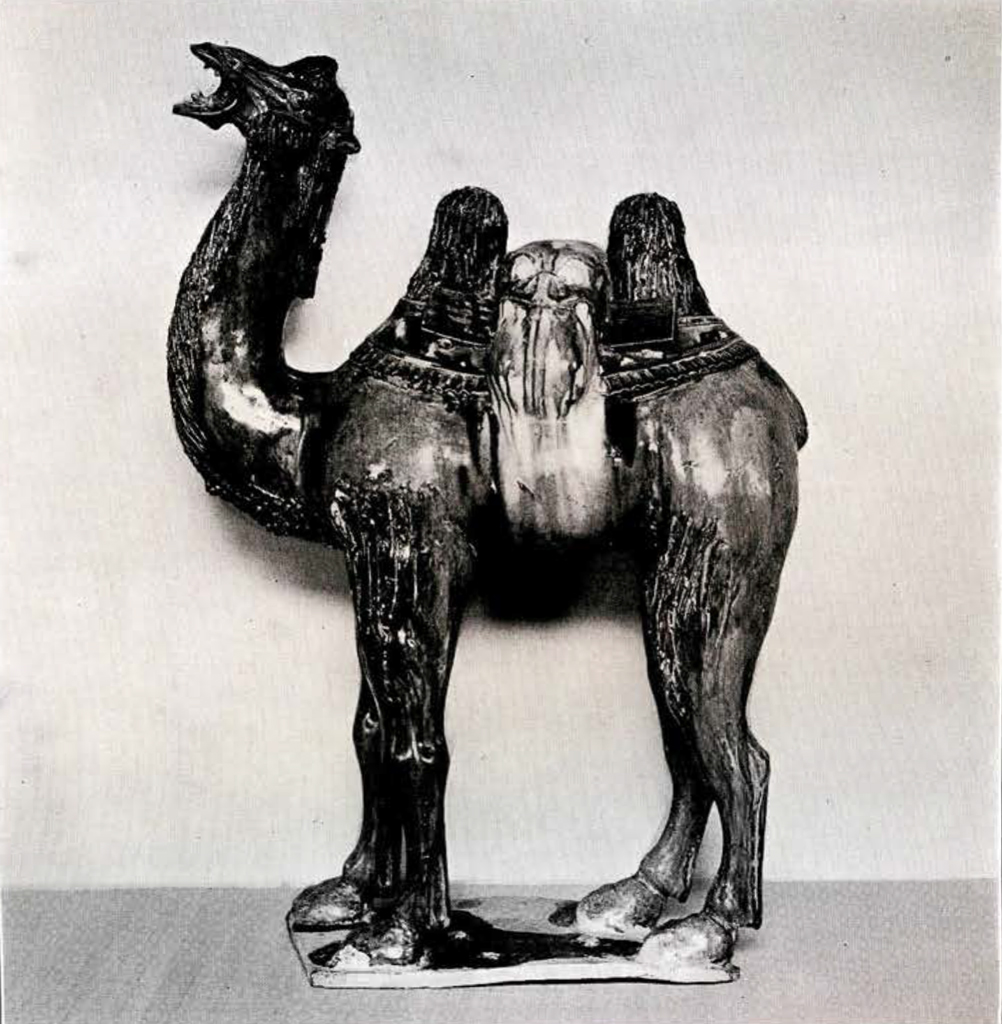 Pottery figurine of a standing two humped camel wearing a saddle with its mouth open