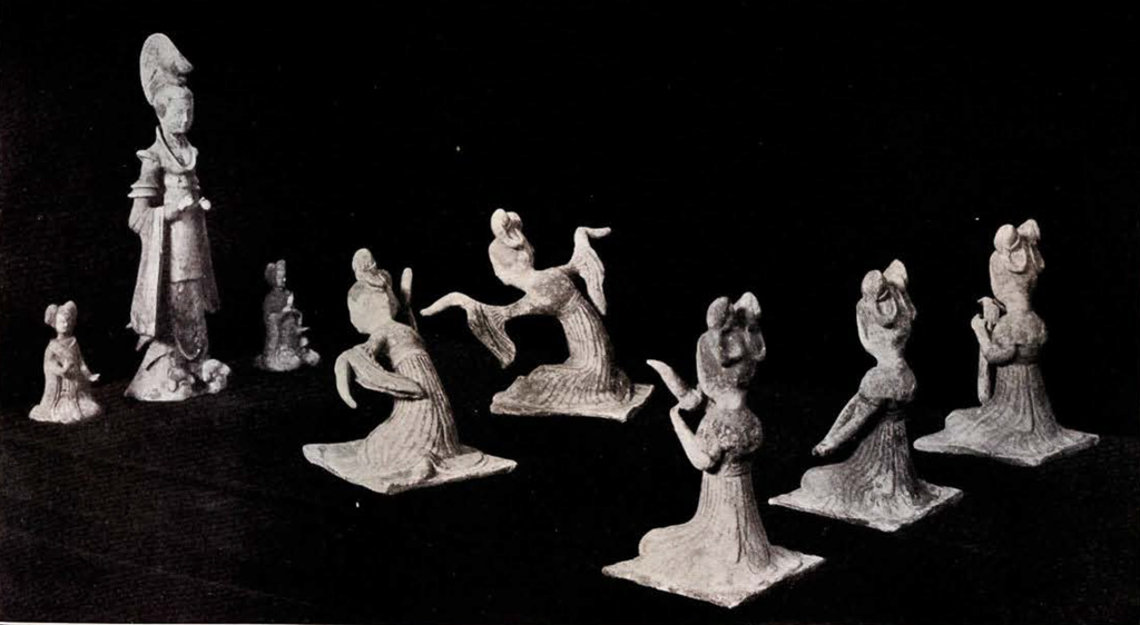 A group of eight figurines, a tall woman with two seated attendents, two dancers and three musicians performing for her