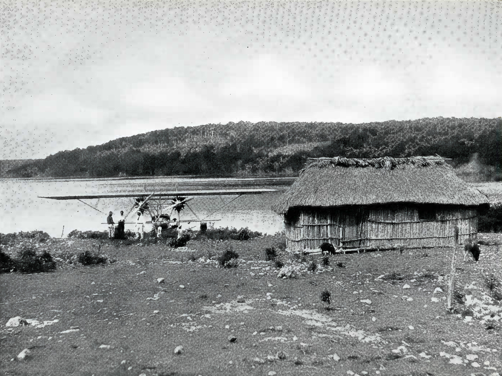 A hut on a shore next to the plane