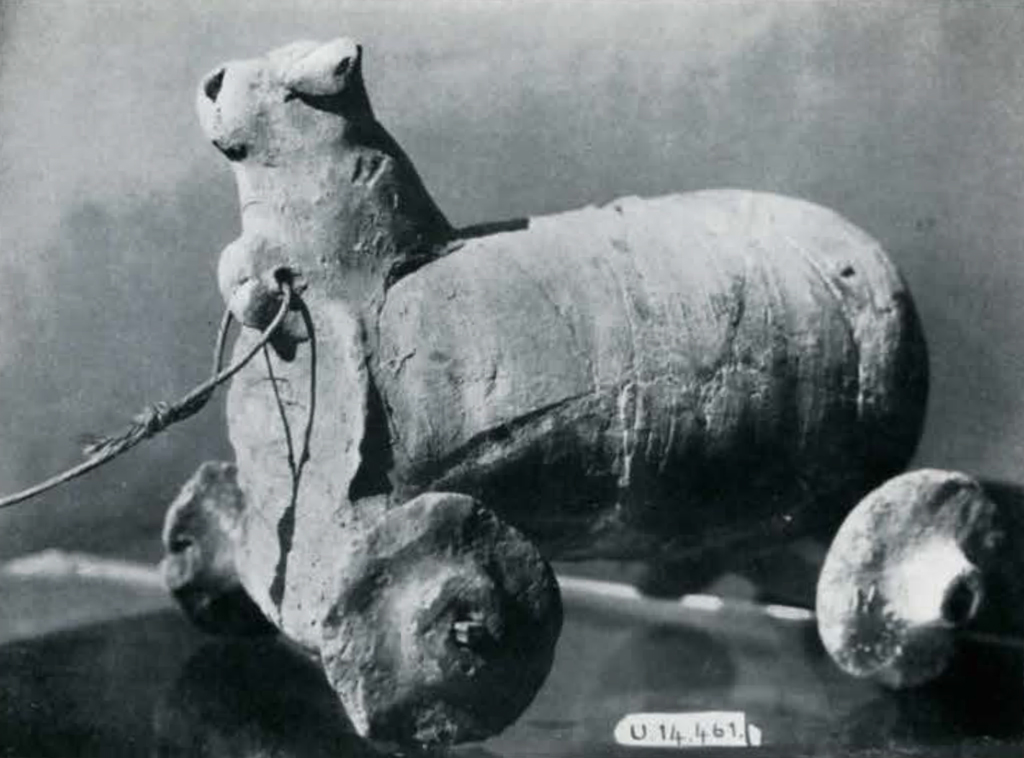 A clay animal on wheels with a string to pull the front