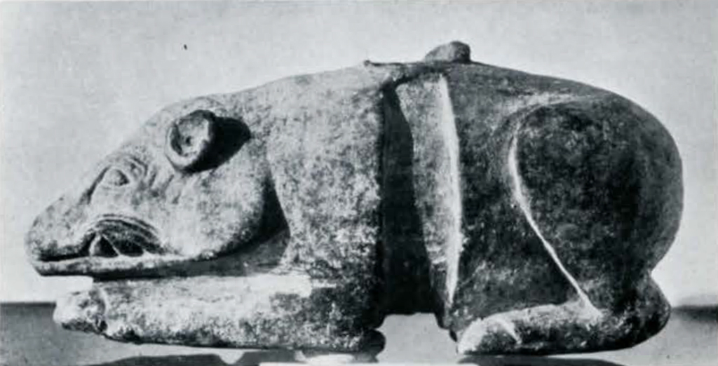 A carved kneeling boar figurine