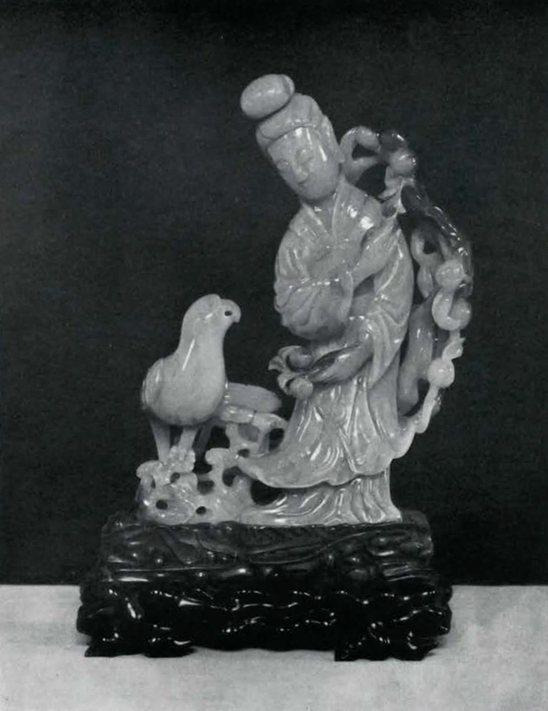 Jade figure of a woman next to a parrot