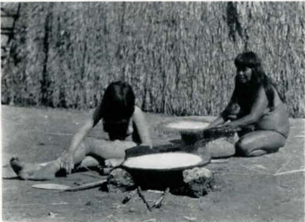 Two women sitting on the ground working at tables