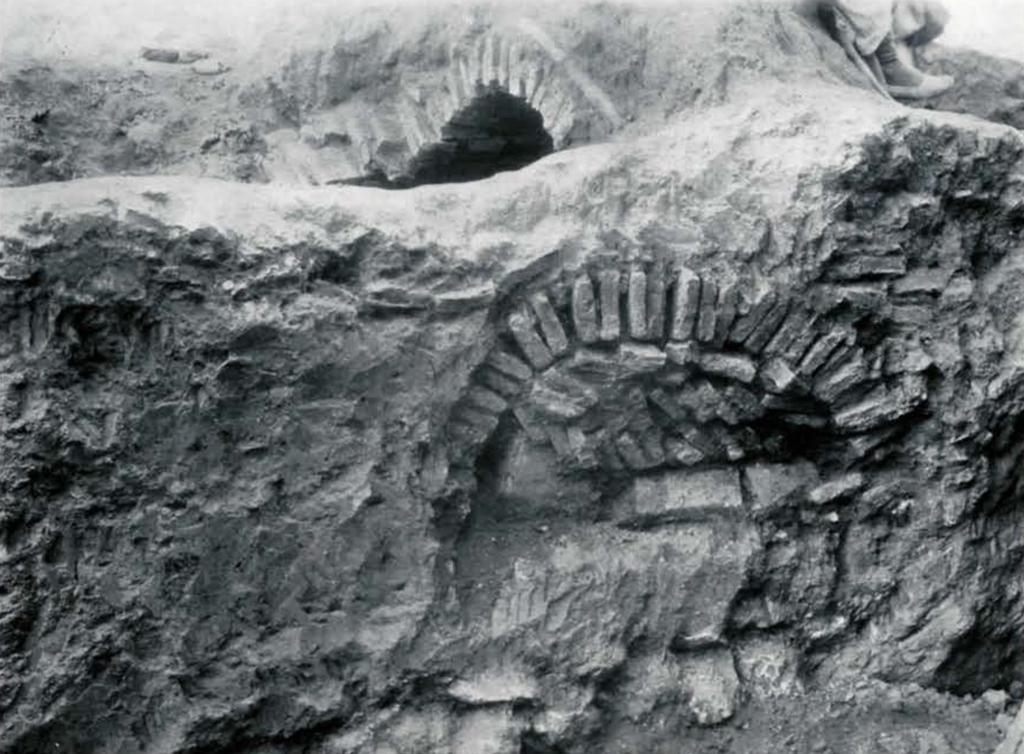 An excavated tomb with brick arch
