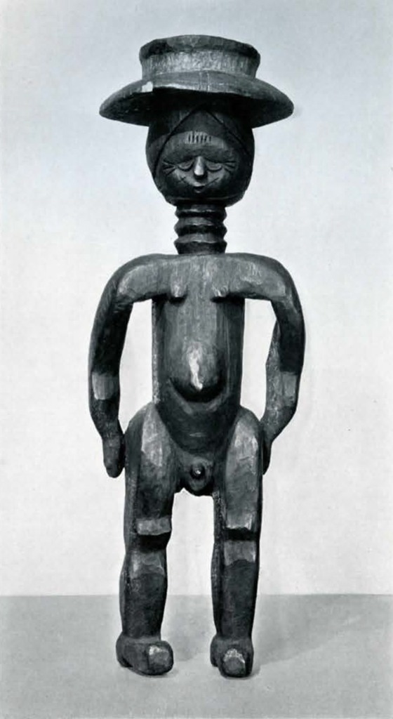 Wooden statue of a standing figure with a long ringed neck and wearing a hat