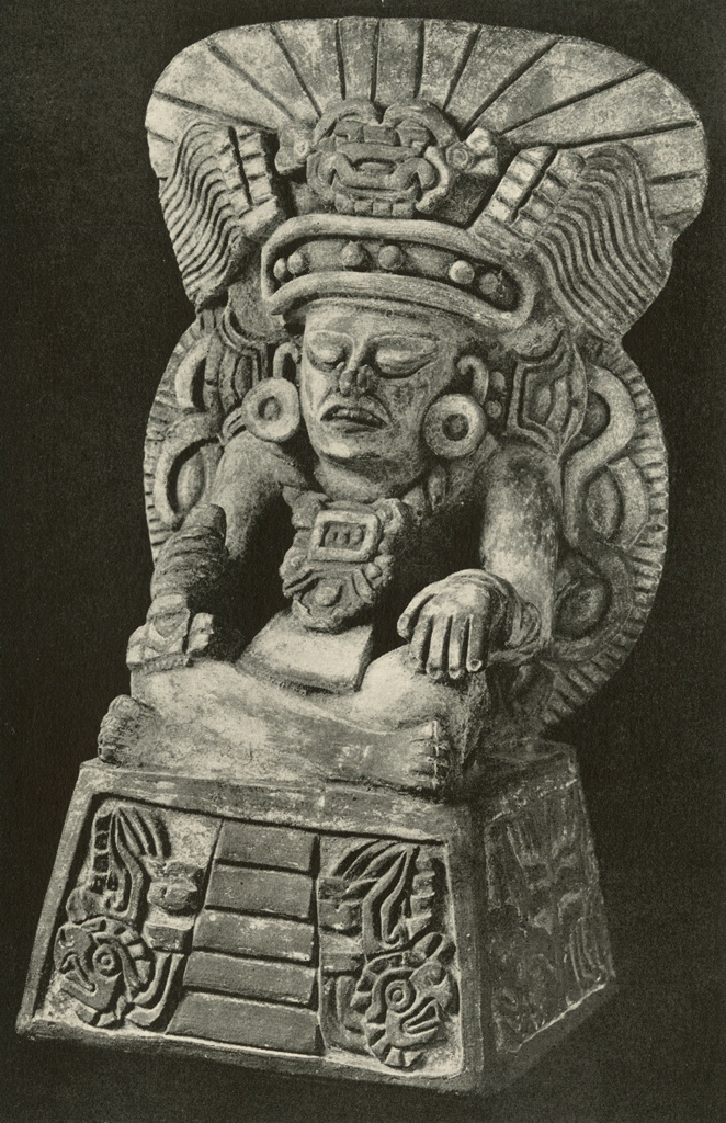 Effigy urn of a seated man with legs crossed in a large headdress, on a pyramid