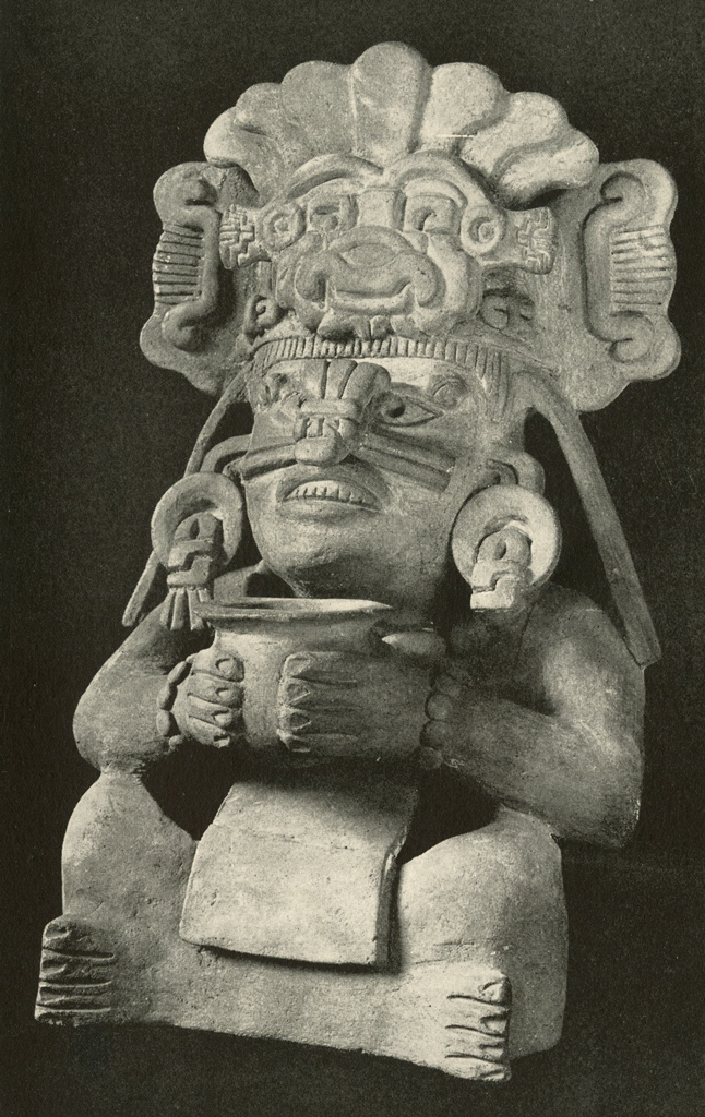 Effigy urn of a seated figure with legs crossed holding a cup or bowl with both hands