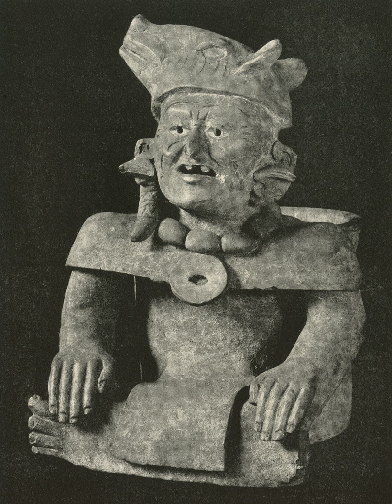 Effigy urn of a seated figure with legs crossed and hands on knees, wearing an animal head as a hat or head piece
